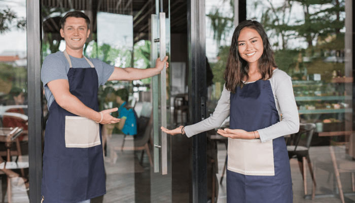 2 persons are holding doors for guests